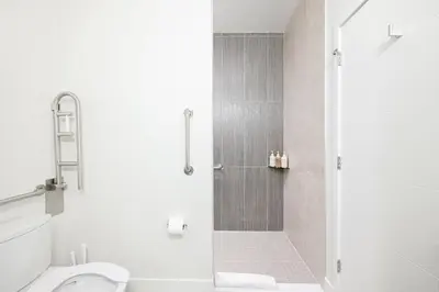 a white bathroom with a shower and a toilet at Relaxed Elegance | Espadin LoHi in Denver