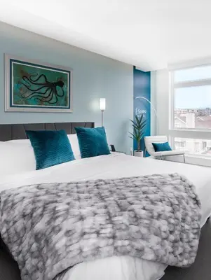 a bedroom with a large white bed with blue pillows at Level-Up Elegance | Espadin LoHi in Denver