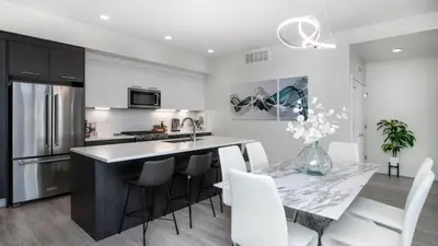 a kitchen and dining room with a marble table and white chairs at Level-Up Elegance | Espadin LoHi in Denver
