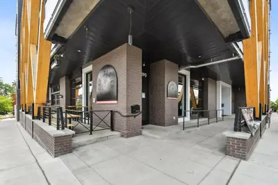 a brick building with a black roof at Chilltop Lounge | Espadin LoHi in Denver