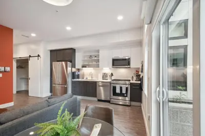 a kitchen with stainless steel appliances and a table at Southwestern Charm | Espadin LoHi in Denver