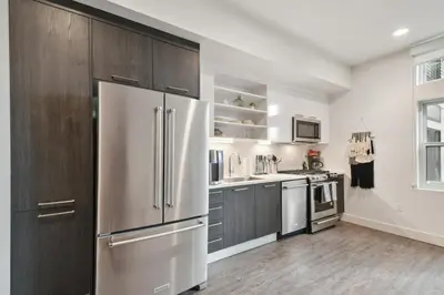 a kitchen with stainless steel appliances and wooden cabinets at Southwestern Charm | Espadin LoHi in Denver