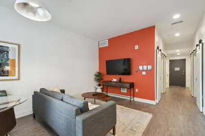 a living room with a couch and a tv on a wall at Southwestern Charm | Espadin LoHi in Denver