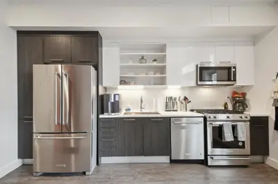 a kitchen with stainless steel appliances and wooden cabinets at Southwestern Charm | Espadin LoHi in Denver