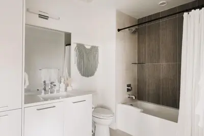 a white bathroom with a toilet and a sink at Rhythm of Night | Espadin LoHi in Denver