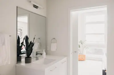 a white bathroom with a sink and a mirror at Rhythm of Night | Espadin LoHi in Denver