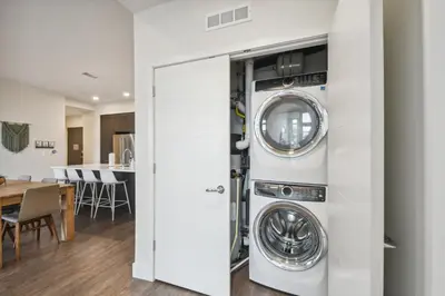 a kitchen and living room with a washer and dryer at Sleek & Chic Vibes | Espadin LoHi in Denver