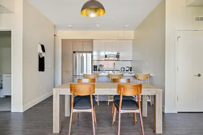 a kitchen and dining room with a wooden table and chairs at Canvas & Comfort | Espadin LoHi in Denver