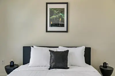 a bed with white pillows and a picture on the wall at Canvas & Comfort | Espadin LoHi in Denver