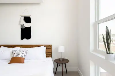 a white bedroom with a bed and a window at Skytop Perspective | Espadin LoHi in Denver