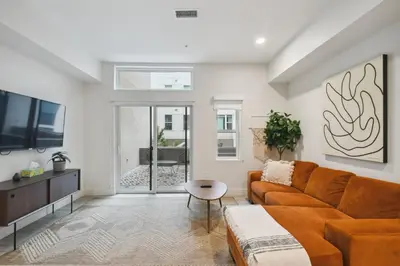 a living room with a couch and a tv at Natural Influence | Espadin LoHi in Denver