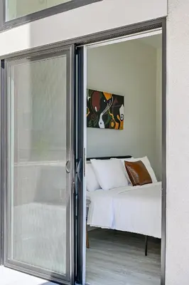 a bedroom with a bed and a sliding glass door at Lofted Living | Espadin LoHi in Denver