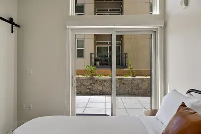 a bedroom with a bed and a sliding glass door at Lofted Living | Espadin LoHi in Denver