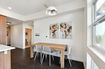 a dining room with a wooden table and chairs at Rosé All Day | Espadin LoHi in Denver