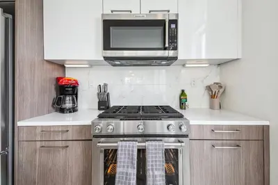 a kitchen with a stove and a microwave at Highline Hideaway | Espadin LoHi in Denver