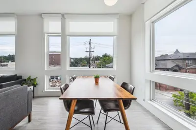 a dining room with a table and chairs and windows at Highline Hideaway | Espadin LoHi in Denver