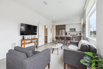 a living room with two couches and a kitchen at Highline Hideaway | Espadin LoHi in Denver