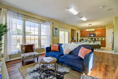 a living room with a blue couch and a kitchen at Lakeview - Gameroom - Pool Table in Henderson