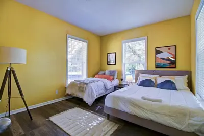 two beds in a room with yellow walls at Lakeview - Gameroom - Pool Table in Henderson