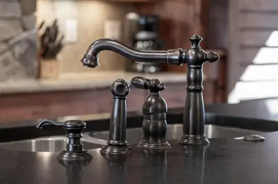 a kitchen sink with a faucet and two figures at Base Camp at Iron Horse,,, townhouse in Winter Park
