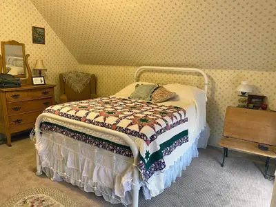a bedroom with a bed with a quilt on it at Pansy’s Parlor Bed & Breakfast in Golden