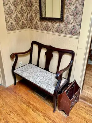 a bench sitting in a room with a wall at Pansy’s Parlor Bed & Breakfast in Golden