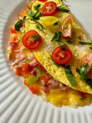 a white plate with a pizza with tomatoes on it at Pansy’s Parlor Bed & Breakfast in Golden