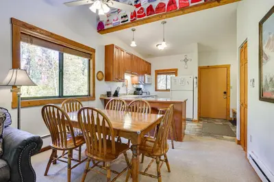 a kitchen and dining room with a wooden table and chairs at Updated Winter Park Condo with Indoor Heated Pool! in Winter Park