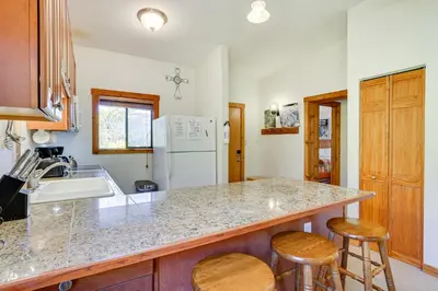 a kitchen with a sink and a counter with stools at Updated Winter Park Condo with Indoor Heated Pool! in Winter Park