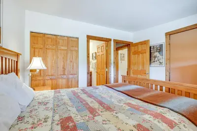 a bedroom with a large bed and wooden cabinets at Updated Winter Park Condo with Indoor Heated Pool! in Winter Park