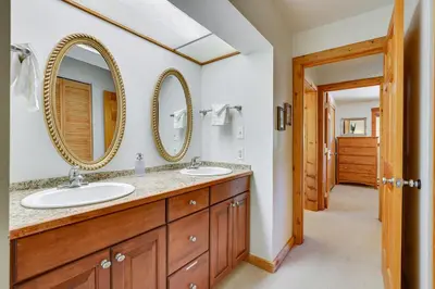 a bathroom with two sinks and two mirrors at Updated Winter Park Condo with Indoor Heated Pool! in Winter Park