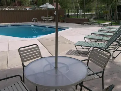 a table with chairs and an umbrella next to a pool at Wild Irishman 2 bed 2 bath retreat WIBH in Keystone