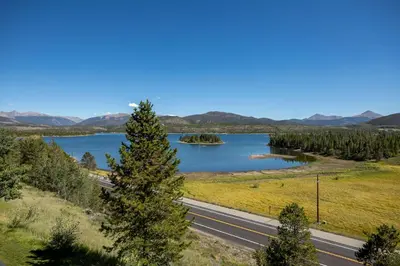 a road next to a lake with a tree at Lake Forest Lakeview Condo: Mountain Views, Close to Town in Frisco