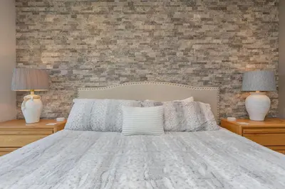 a bedroom with a bed with two lamps and a brick wall at Lake Forest Lakeview Condo: Mountain Views, Close to Town in Frisco