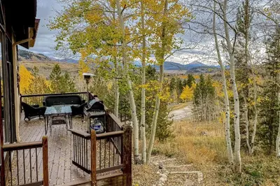 a porch of a house with a grill and trees at CoCo Chalet in Silverthorne