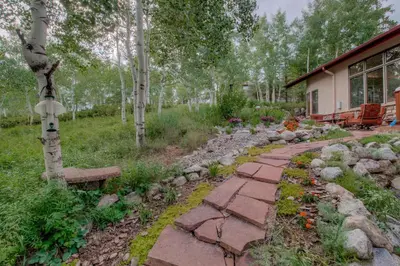 a garden with a stone walkway next to a house at CoCo Chalet in Silverthorne