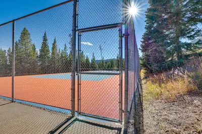 a fence with a tennis court behind it at Cozy Condo with Balcony and Mtn Views in Silverthorne in Silverthorne