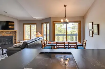 a living room with a couch and a table at 6 Mi to Winter Park Mtn-View Condo with Balcony! in Fraser