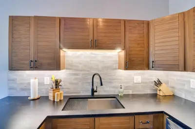 a kitchen with a sink and wooden cabinets at 6 Mi to Winter Park Mtn-View Condo with Balcony! in Fraser