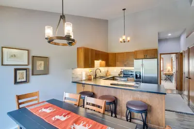 a kitchen with a table and chairs and a counter top at 6 Mi to Winter Park Mtn-View Condo with Balcony! in Fraser