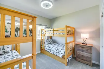 a bedroom with two bunk beds and a table at Ski-InandSki-Out Granby Townhouse with Private Hot Tub in Granby