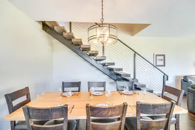 a dining room with a table with chairs and a staircase at Ski-InandSki-Out Granby Townhouse with Private Hot Tub in Granby