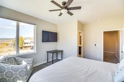 a bedroom with a bed and a ceiling fan at Ski-InandSki-Out Granby Townhouse with Private Hot Tub in Granby