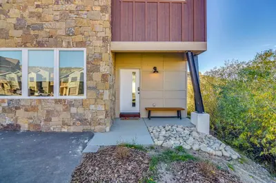 a stone house with a bench on the front door at Ski-InandSki-Out Granby Townhouse with Private Hot Tub in Granby