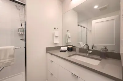 a white bathroom with a sink and a mirror at New Condo! Skiboard Winter Park Shuttle in Fraser