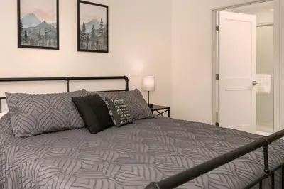 a bedroom with a bed with a gray comforter at New Condo! Skiboard Winter Park Shuttle in Fraser