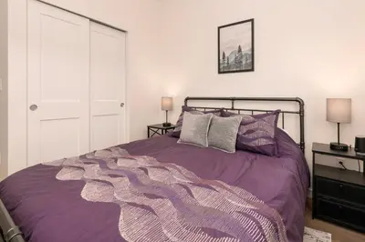 a bedroom with a purple bed with two lamps at New Condo! Skiboard Winter Park Shuttle in Fraser
