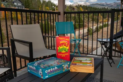 a chair and a box and a book on a porch at New Condo! Skiboard Winter Park Shuttle in Fraser