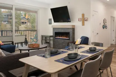a living room with a table and a fireplace at New Condo! Skiboard Winter Park Shuttle in Fraser