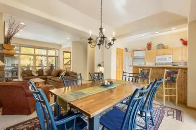 a dining room and living room with a wooden table and chairs at 1952 Northstar townhouse in Keystone